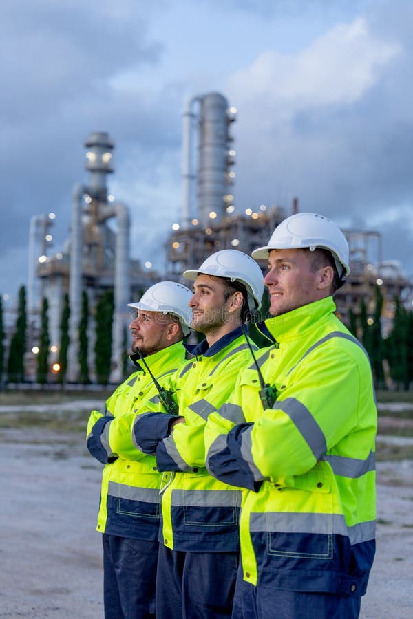 Vertical image of factory engineer or technician workers stand in the row and look to left side with arm-crossed stand in front of royalty free stock photography