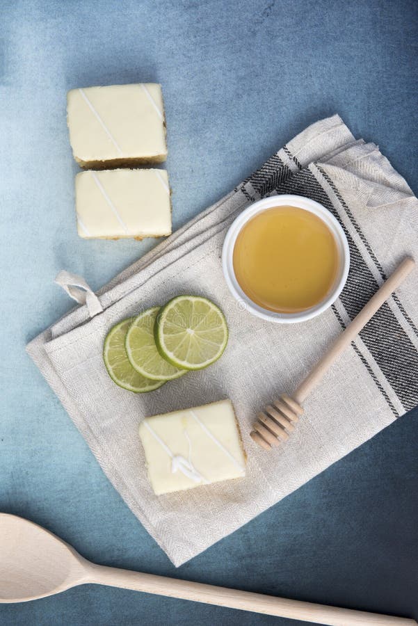 Vertical image of three lemon cakes with lime slices and a pot of honey stock photography Vertical image of three lemon cakes with lime slices and a pot of honey stock photography