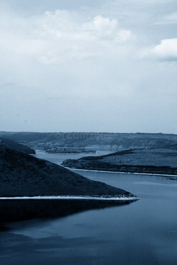 Vertical landscape, background of wide river between hills, classic blue 2020 color, trendy monochrome toning stock image Vertical landscape, background of wide river between hills, classic blue 2020 color, trendy monochrome toning stock image