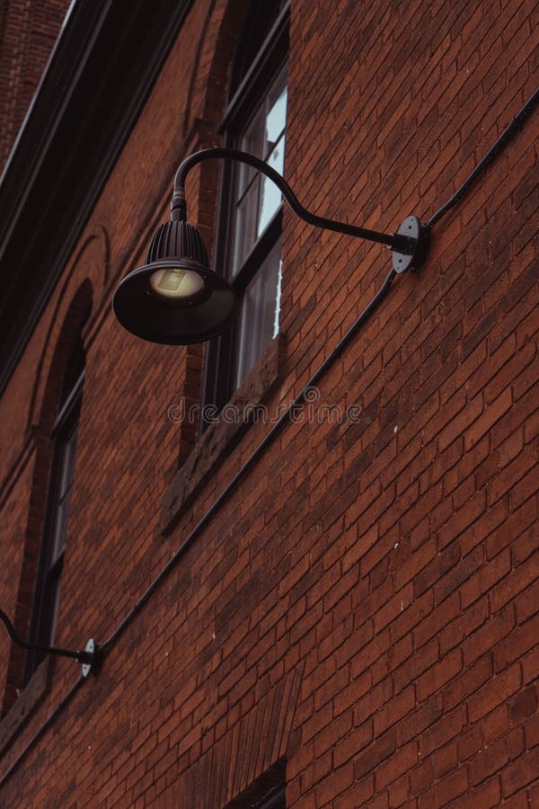 Vertical Low Angle Shot of a Street Light Attached To the Red Brick
