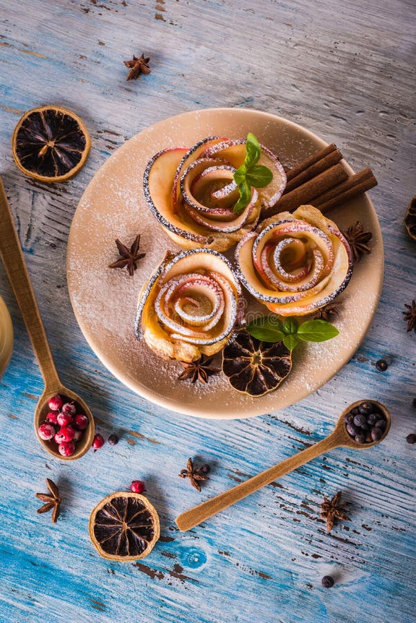 Crispy apple roses on color plate with several herbs and spices