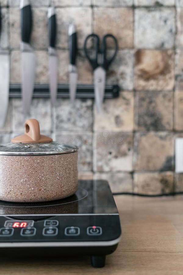 Pan at Small Electric Stove with Control Panel in Kitchen Stock Photo