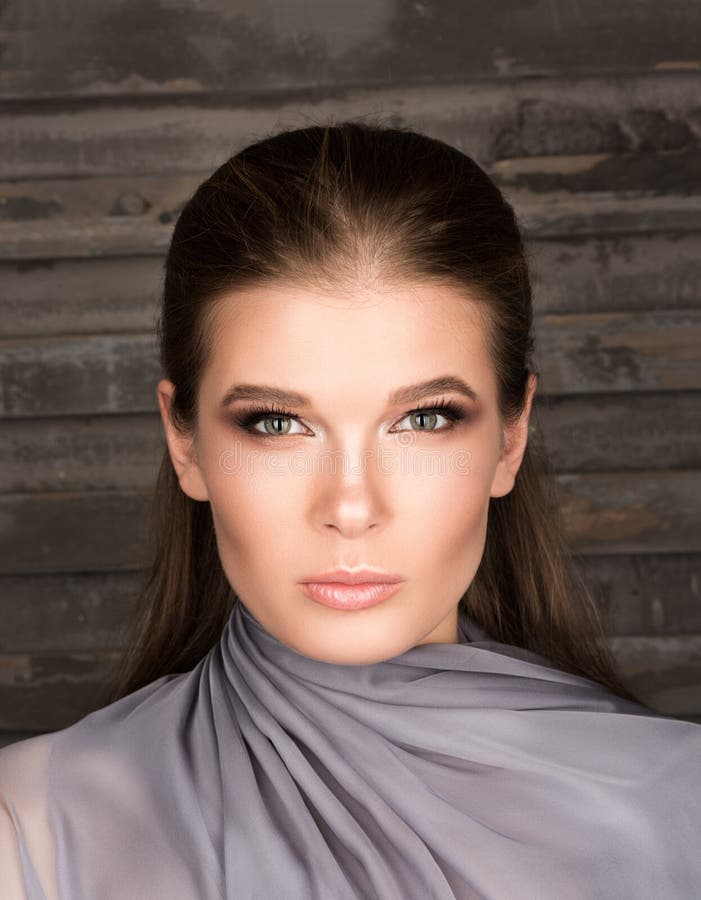 Vertical Portrait Of A Beautiful Young Woman Against The Dark Wall