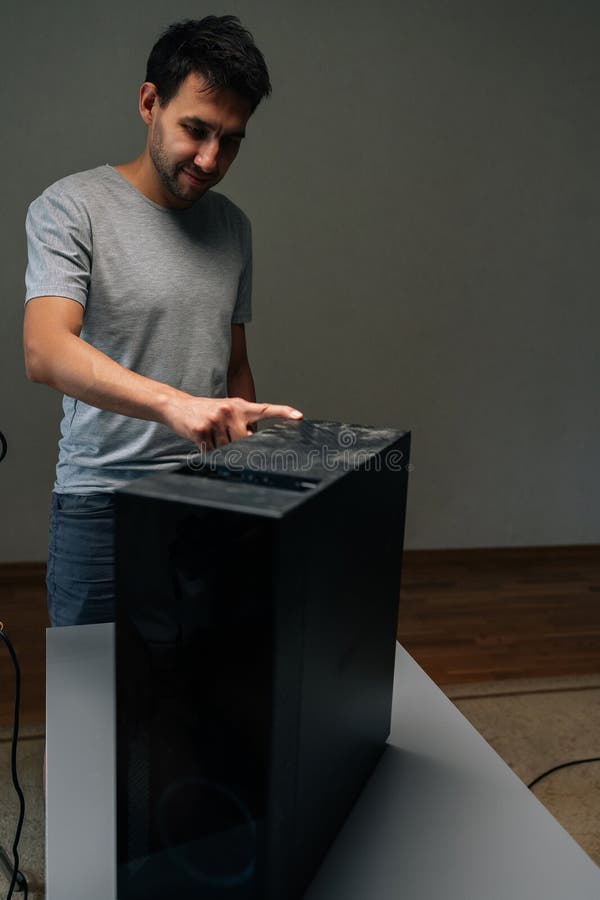 Vertical portrait of technician pointing at thick dust layer covering computer case, demonstrating potential hardware royalty free stock image