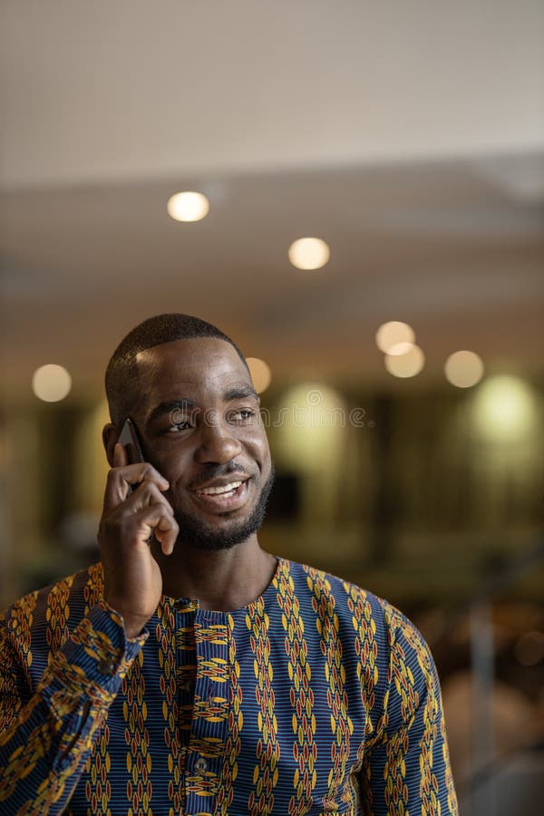 Vertical portrait traditional black African entrepreneur using phone