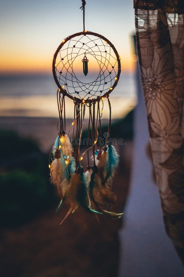 Beautiful handmade dream catcher near river at sunset. Space for text  Photos