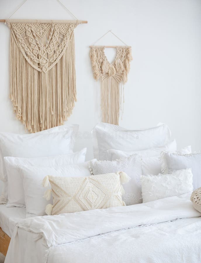 Vertical Shot of a Bed on Background of a Wall Decorated with Macrame