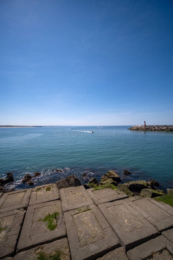 Vertical shot of breakwall and immense rock formations on coastline royalty free stock photography