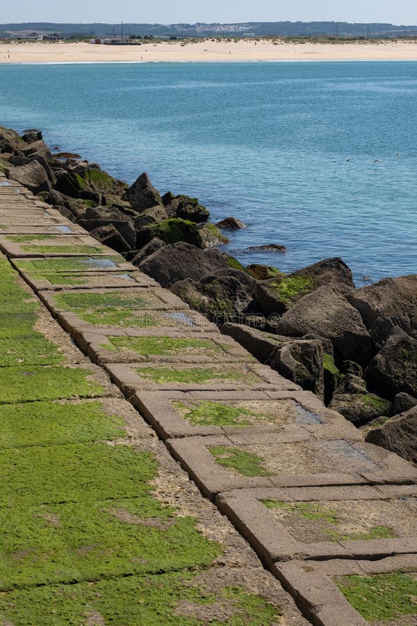 Vertical shot of breakwall and immense rock formations on coastline royalty free stock image