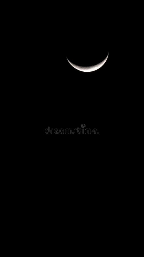 The vertical shot of crescent moon in the dark night sky stock images