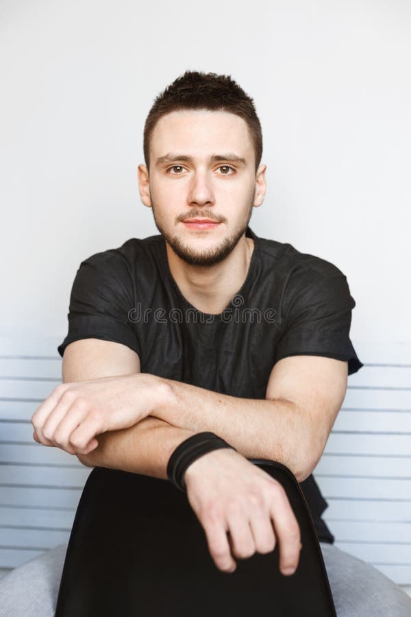 Vertical Shot of Guy Sitting on Chair, Hands on Chairback. Stock Photo Image of modern, break