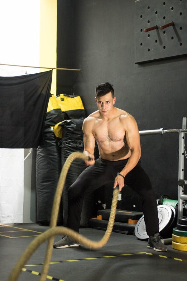 Vertical shot of a Hispanic sporty man doing a rope workout royalty free stock images