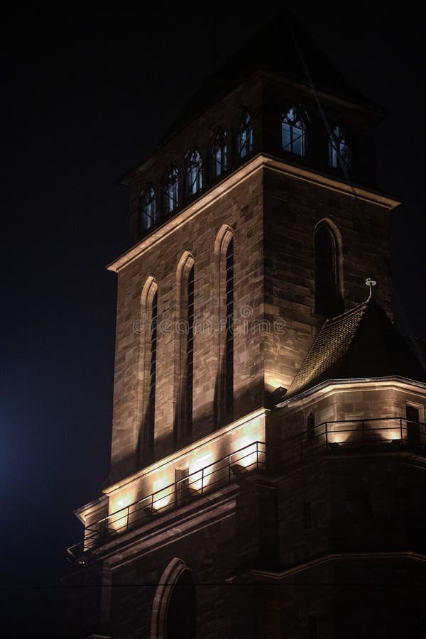 Vertical shot of medieval building illuminated by lights in Strasbourg at night stock images