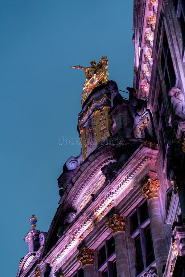Vertical shot of a medieval building illuminated with pink lights royalty free stock photography