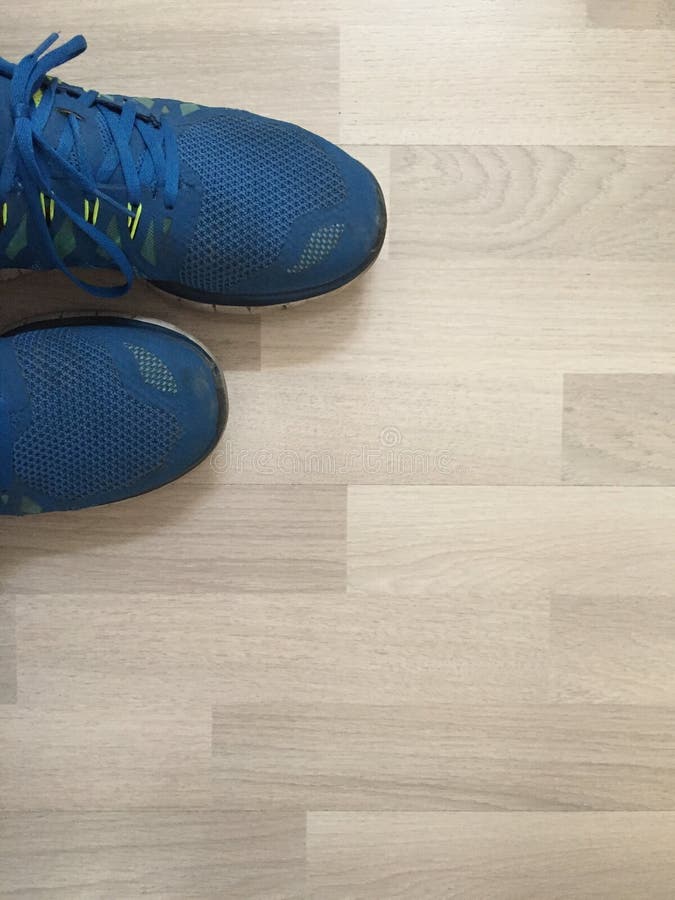 Vertical Shot of a Pair of Blue Running Shoes on a Wooden Surface Stock ...