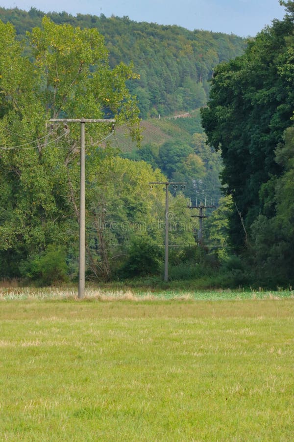 Vertical Shot of the Rural Electrical Post by the Road Stock Image