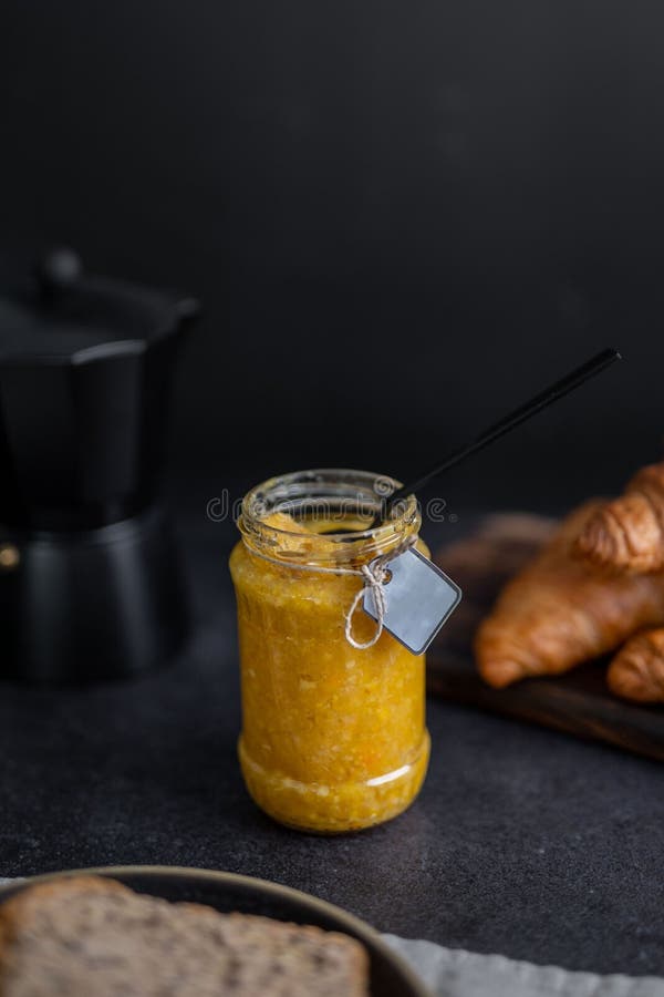Vertical Shot of a Yellow Marmalade in a Labeled Glass Jar on the Table