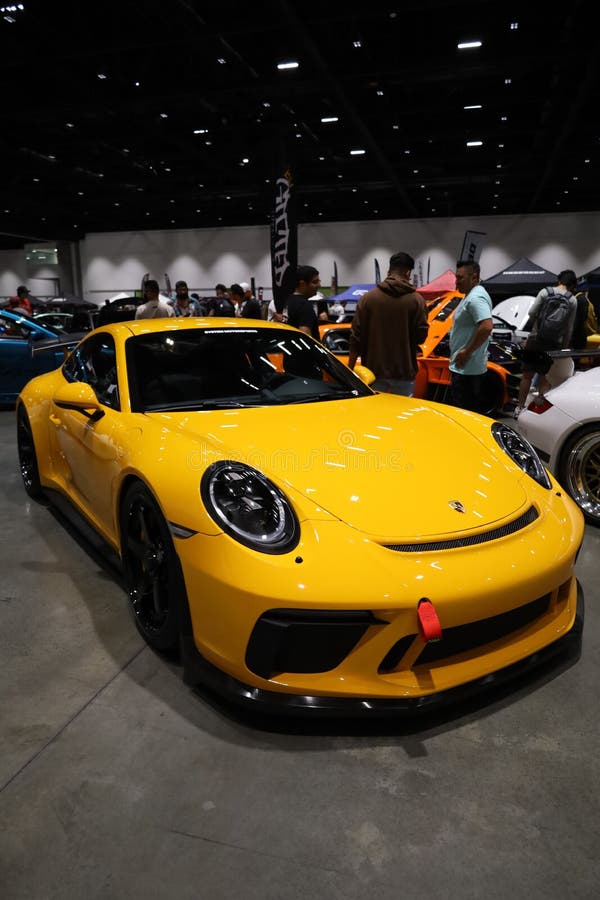 Vertical Shot of a Yellow Porsche Car in the Car Show Editorial
