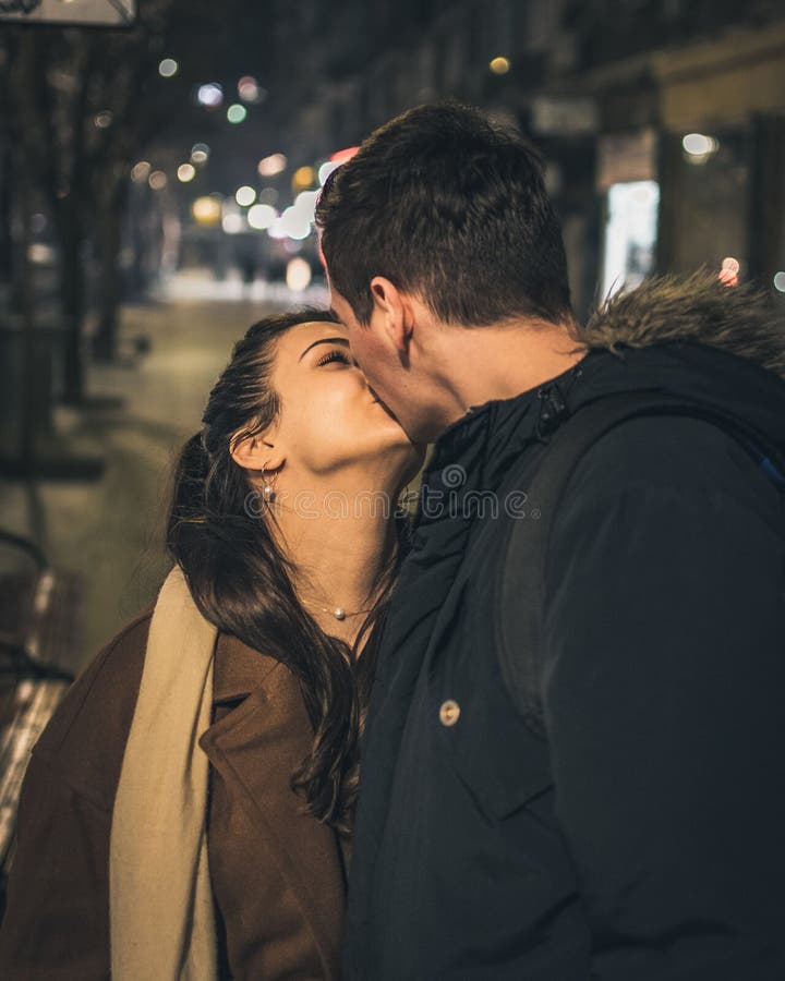Vertical Shot of a Young Caucasian Couple Kissing on the Street at ...