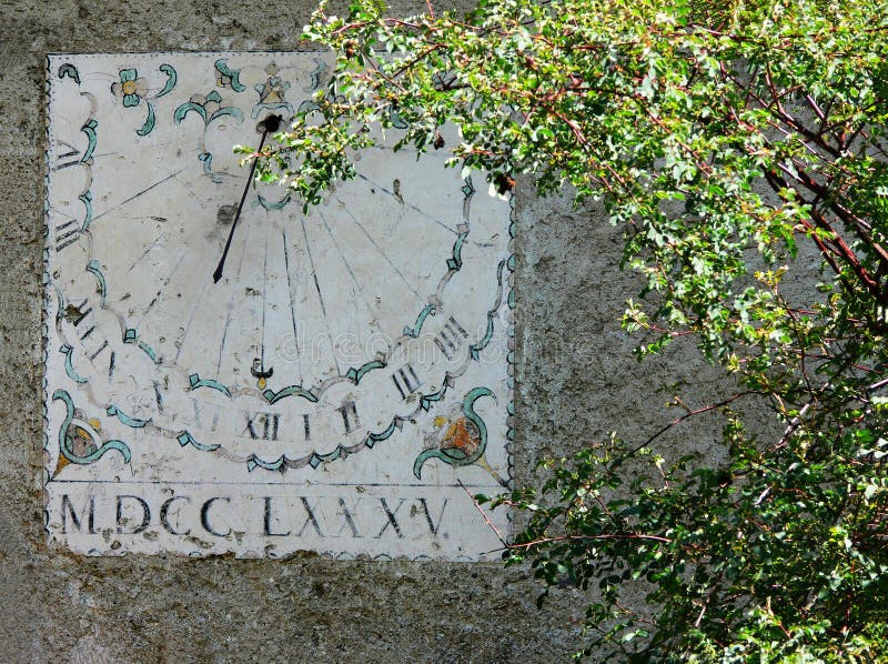 Vertical sundial timepiece of ancient times painted on a wall