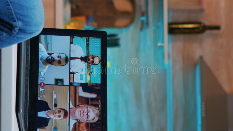 Vertical video Freelancer discussing with partners online using laptop stock video