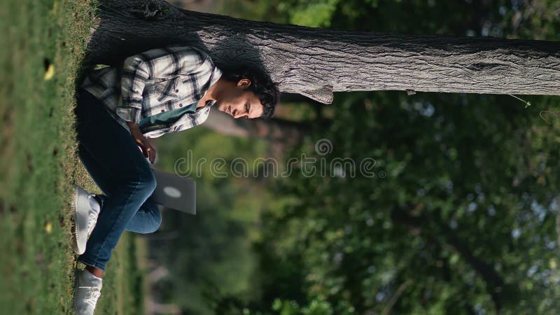 VERTICAL VIDEO POV happy Turkish man business freelancer e learning working laptop summer sunny park stock video