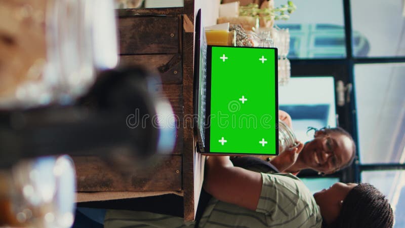 Vertical Video Women chats about products next to laptop with greenscreen