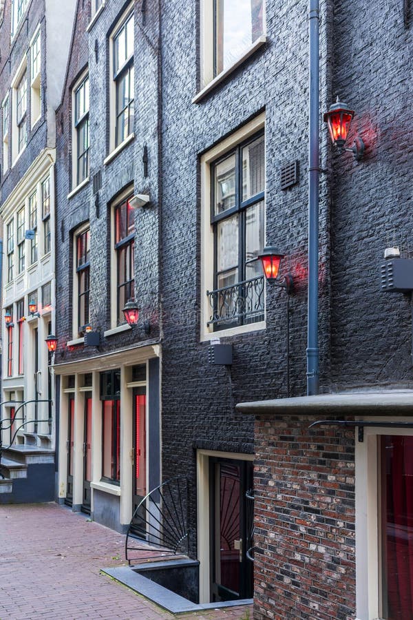 Vertical view of red lanterns on black painted brick building illuminated at dusk royalty free stock photo