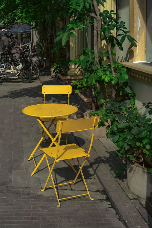 Vertical View of Yellow Chairs and Table on the Sidewalk Stock Image