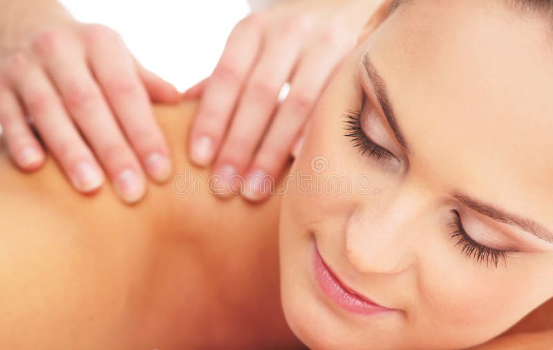 Portrait of a young and attractive blond Caucasian woman laying on a massage procedure. The image is isolated on a white background. Portrait of a young and attractive blond Caucasian woman laying on a massage procedure. The image is isolated on a white background.