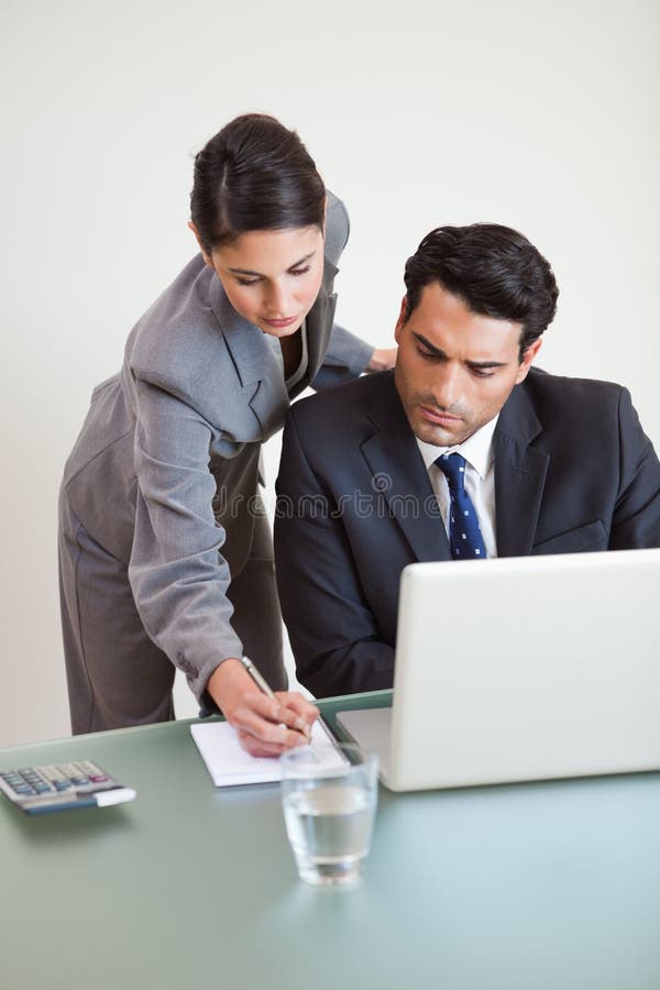 Verticale d'une équipe belle d'affaires travaillant avec un ordinateur portable images stock