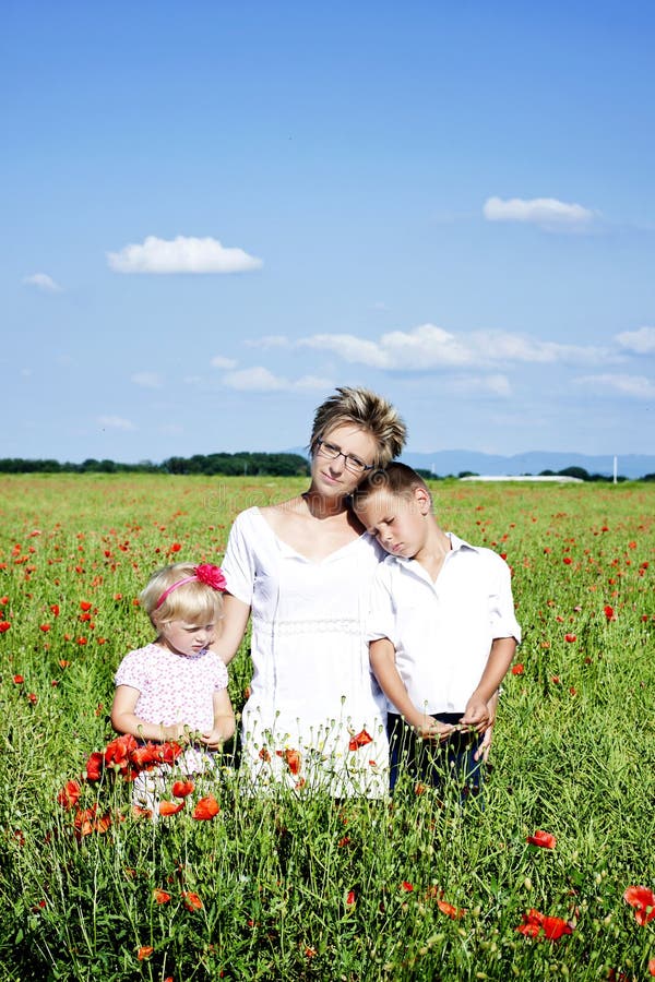 Verticale de famille mignonne dans le domaine de pavot photographie stock libre de droits Verticale de famille mignonne dans le domaine de pavot photographie stock libre de droits