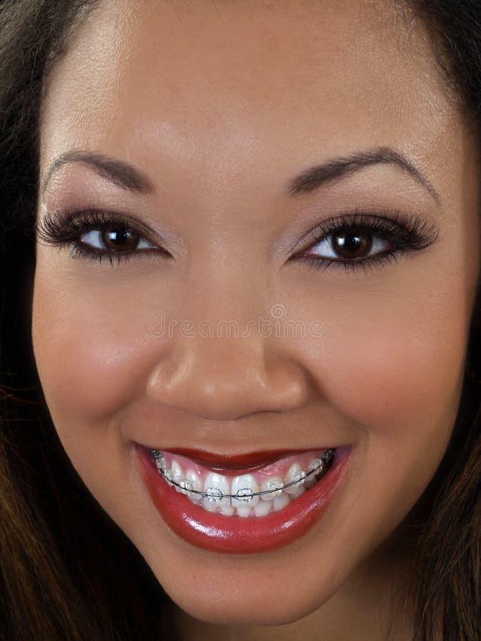 Verticale serrée de femme de couleur de sourire avec des supports image stock Verticale serrée de femme de couleur de sourire avec des supports image stock