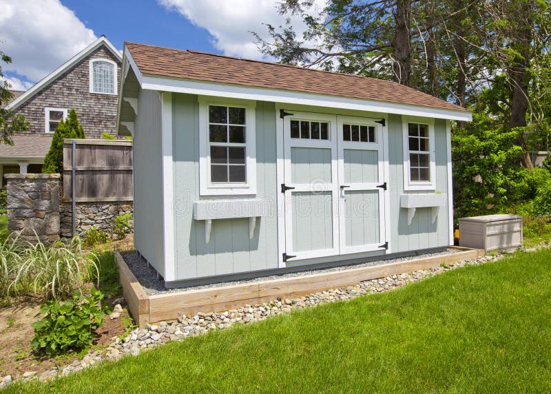 New blue garden shed in beautiful garden. New blue garden shed in beautiful garden