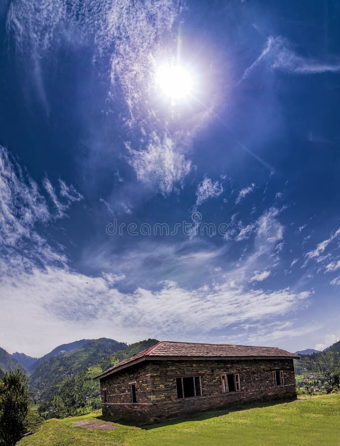 Vertikal panorama- Janjehli dal och flerfärgad taklagd koja arkivfoto