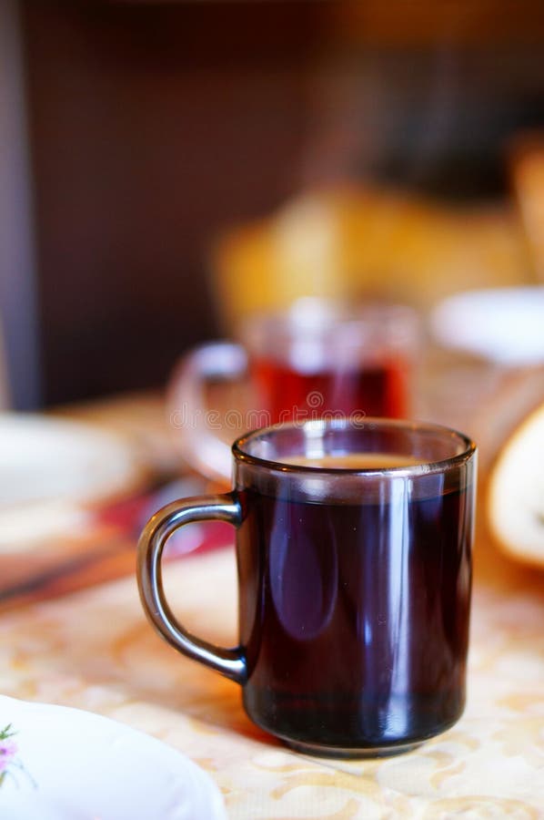 Vertikaler Schuss eines schwarzen Getränks in einem Becher in der Tabelle lizenzfreies stockbild