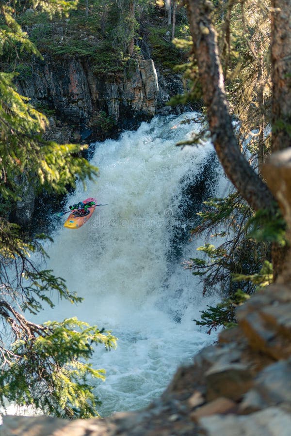 Vertikaler Schuss extremen Kajakfahrens über massiven Wasserfall stockfotos
