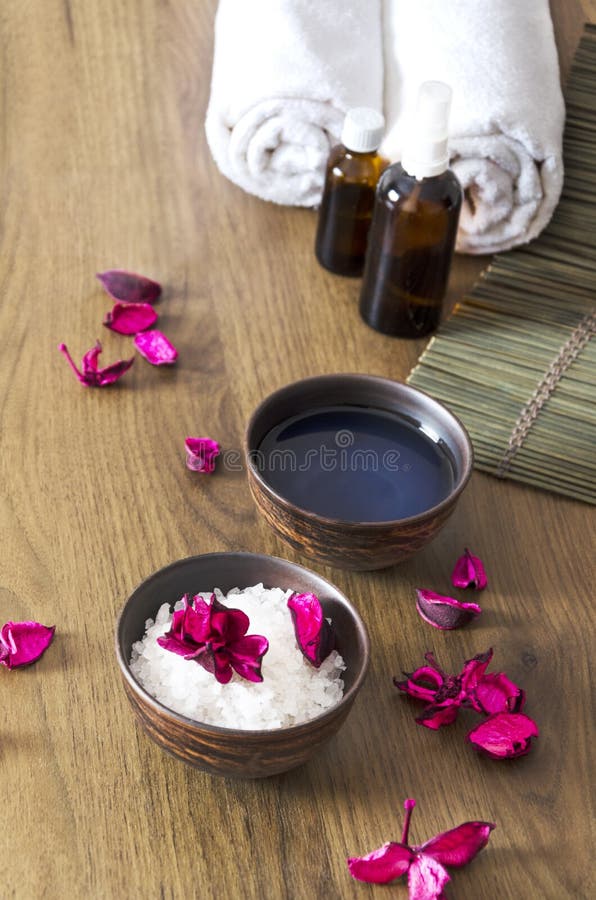 Vertikaler Schuss Vorbereitung für Massagetherapie Schüsseln mit kosmetischen Waren und der Blumenblattherstellung entspannen sic lizenzfreie stockfotografie Vertikaler Schuss Vorbereitung für Massagetherapie Schüsseln mit kosmetischen Waren und der Blumenblattherstellung entspannen sic lizenzfreie stockfotografie