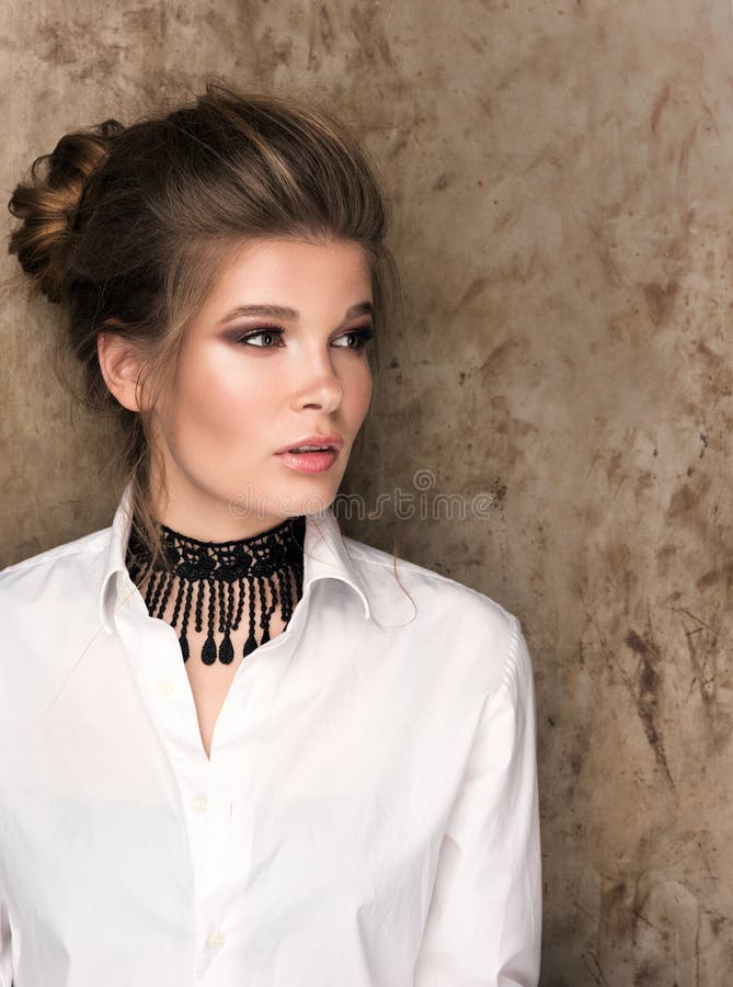 Vertikales Porträt einer schönen jungen Frau in einem weißen Hemd mit einem schwarzen Halsband auf ihrem Hals lizenzfreie stockfotos Vertikales Porträt einer schönen jungen Frau in einem weißen Hemd mit einem schwarzen Halsband auf ihrem Hals lizenzfreie stockfotos