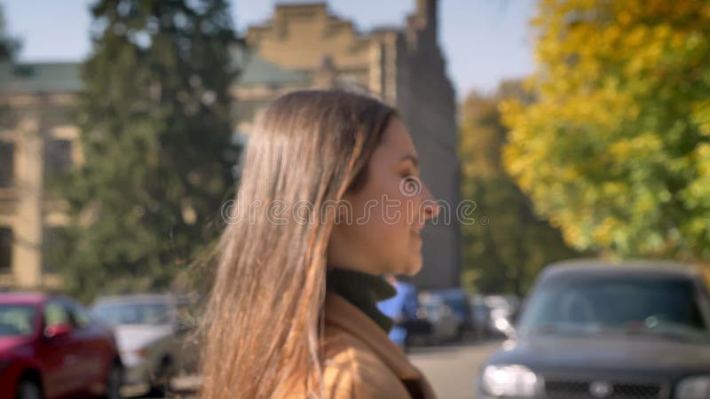 Vervuilend in motie, glimlacht het Kaukasische wijfje bij camera gelukkig en dat die recht terwijl het gaan op de straat kijken