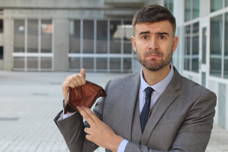 Verwarde zakenman die zijn lege portefeuille houden stock foto's Verwarde zakenman die zijn lege portefeuille houden stock foto's