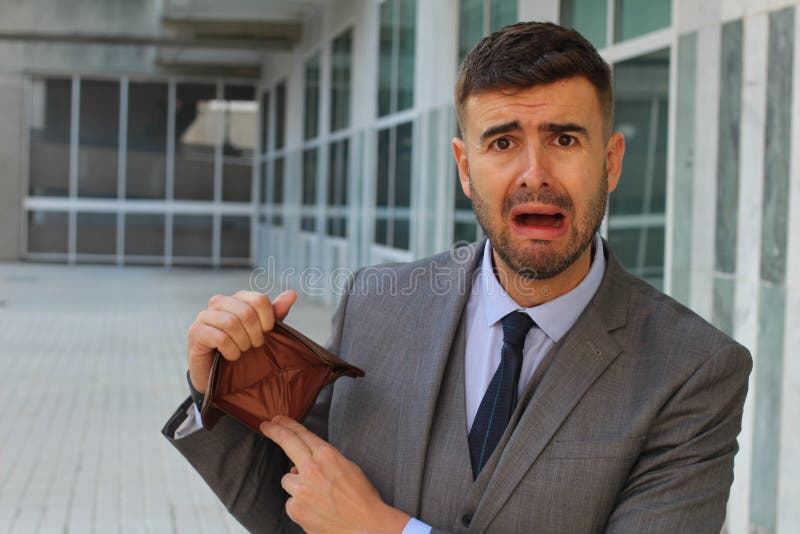 Verwarde zakenman die zijn lege portefeuille houden stock afbeeldingen Verwarde zakenman die zijn lege portefeuille houden stock afbeeldingen