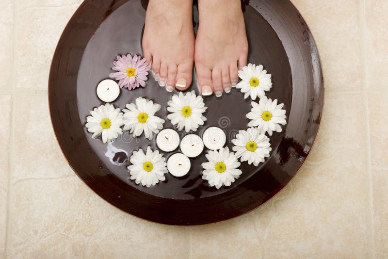 Woman's feet in a bowl of water with flowers. Woman's feet in a bowl of water with flowers