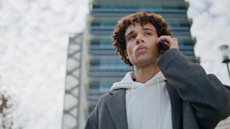Verwirrte junge Leute, die Mobiltelefone in städtischen Umgebungen anrufen. junger Mann, der wartet stockfotos
