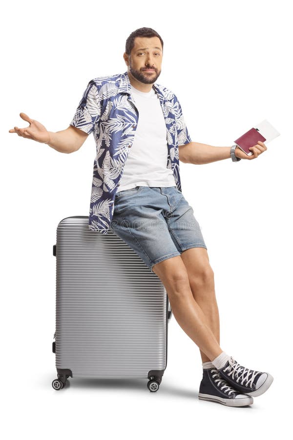 Verwirrter männlicher Tourist, der einen Pass besitzt und auf einem Koffer sitzt lizenzfreie stockfotografie