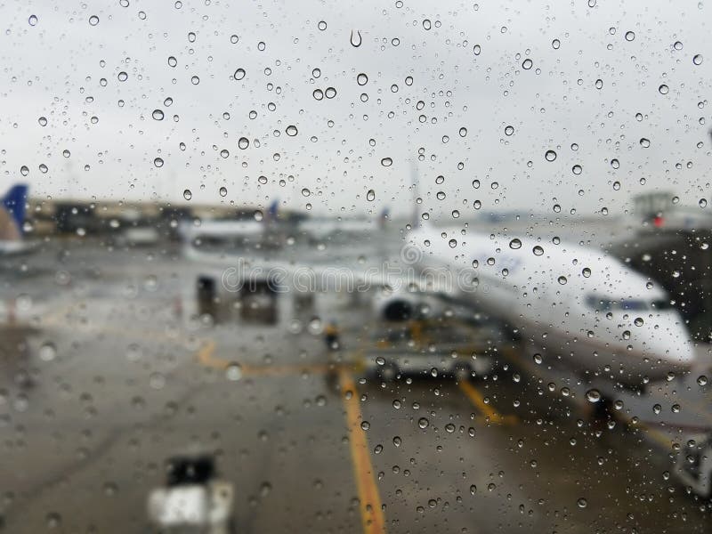 Water droplets and stormy gray skies hide United Airlines Boeing 737. Airport rainy day with delays and dark skies gives holiday traveling passengers a rainy mood. For more similar images, please visit. Water droplets and stormy gray skies hide United Airlines Boeing 737. Airport rainy day with delays and dark skies gives holiday traveling passengers a rainy mood. For more similar images, please visit