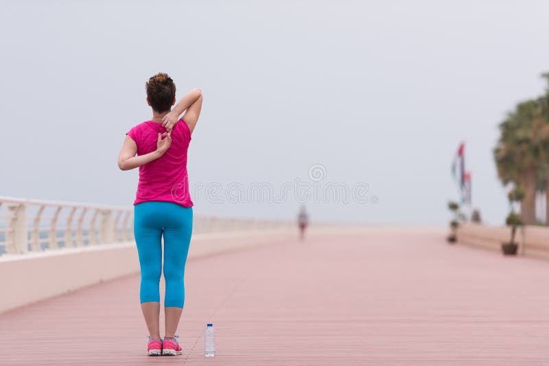Woman stretching and warming up on the promenade