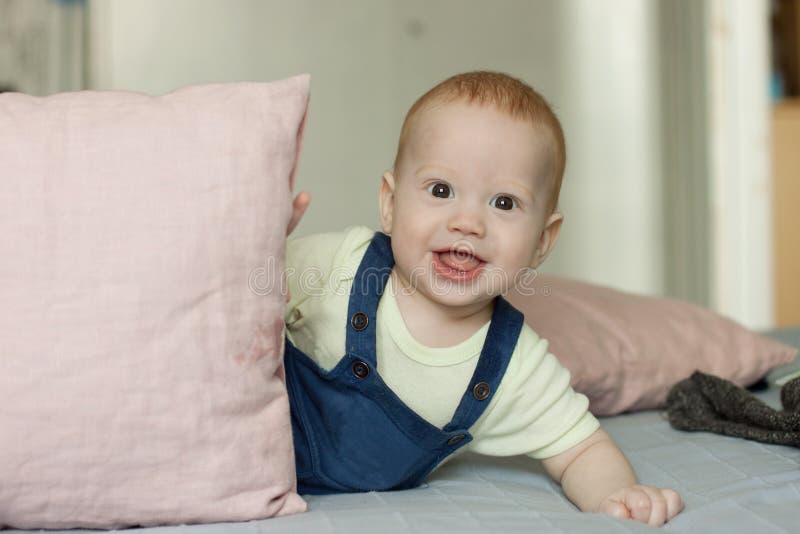 Very curious baby stares while playing with pillows stock photos