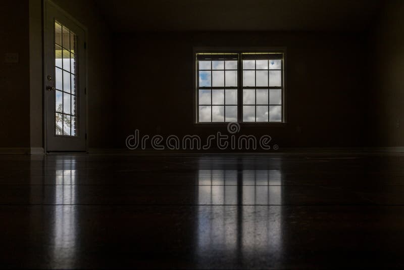 A Very Dark and almost Black Room with the only Light Coming in through the Window and Door