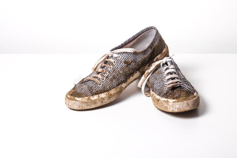 very Muddy Trainers white shoes on white background.